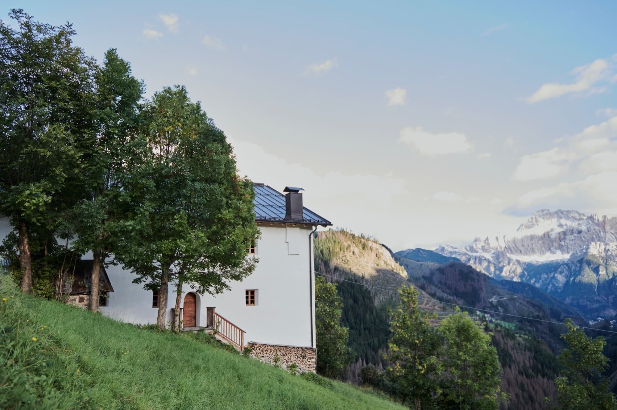 Casa tra cime in its summer setting above the Dolomites